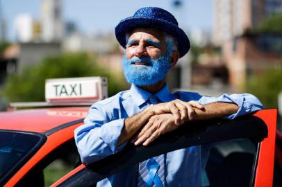 Porto Alegre, RS, Brasil, 18-11-2022: O taxista Newton Roberto Lopes Boa Nova, 69 anos, trabalha vestido de azul e com o carro decorado em novembro. A campanha Novembro Azul busca estimular a conscientização sobre a necessidade de realizar o exame para prevenir câncer de próstata. Foto: Mateus Bruxel / Agência RBSIndexador: Mateus Bruxel<!-- NICAID(15269112) -->