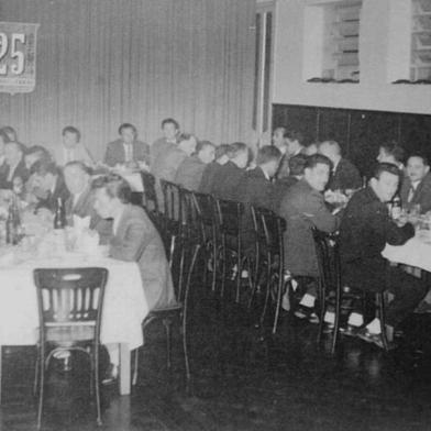 Funcionários de diversas seções da fábrica celebraram o aniversário de 25 anos da Metalúrgica Gazola durante jantar no Clube Juvenil, em 1957. Além dos diretores na mesa ao fundo (José Ariodante Mattana, José Gazola, Sylvio Gazola e Ivo Gazola), participaram do jantar Cipriano Torresini, Henrique Gazola, Armindo Gubert, Vicente Luiz Marcon e diversos outros colegas.<!-- NICAID(15269062) -->