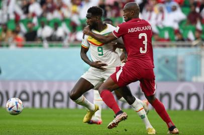 Senegals forward #09 Boulaye Dia (L) and Qatars defender #03 Karim Hassan Abdel fight for the ball during the Qatar 2022 World Cup Group A football match between Qatar and Senegal at the Al-Thumama Stadium in Doha on November 25, 2022. (Photo by OZAN KOSE / AFP)Editoria: SPOLocal: DohaIndexador: OZAN KOSESecao: soccerFonte: AFPFotógrafo: STF<!-- NICAID(15276315) -->