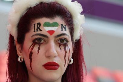 An Iran supporter with her face made up to show tears of blood under a heart in the Iranian colours, poses for photographs ahead of the Qatar 2022 World Cup Group B football match between Wales and Iran at the Ahmad Bin Ali Stadium in Al-Rayyan, west of Doha on November 25, 2022. - Iran has been rocked by more than seven weeks of nationwide protests over the death of 22-year-old Kurdish Iranian woman Masha Amini while in the custody of the Tehran morality police (Photo by Giuseppe CACACE / AFP)Editoria: SPOLocal: DohaIndexador: GIUSEPPE CACACESecao: soccerFonte: AFPFotógrafo: STF<!-- NICAID(15276780) -->