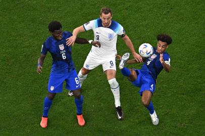 USAs midfielder #06 Yunus Musah (L) and USAs midfielder #04 Tyler Adams (R) fight for the ball with Englands forward #09 Harry Kane (C) during the Qatar 2022 World Cup Group B football match between England and USA at the Al-Bayt Stadium in Al Khor, north of Doha on November 25, 2022. (Photo by MANAN VATSYAYANA / AFP)<!-- NICAID(15277023) -->