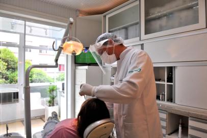 CAXIAS DO SUL, RS, BRASIL, 28/11/2022. Quem quer dá um jeito: no trabalho ou no dentista, brasileiros acompanham como podem a Copa do Mundo. Na foto, Leonardo Hainzenreder (dentista) e Natália Montemezzo (paciente). (Neimar De Cesero/Agência RBS)<!-- NICAID(15279019) -->