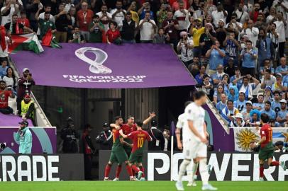 Portugals forward #07 Cristiano Ronaldo (C) celebrates with Portugals midfielder #08 Bruno Fernandes (L) and Portugals midfielder #10 Bernardo Silva after he scored his teams first goal during the Qatar 2022 World Cup Group H football match between Portugal and Uruguay at the Lusail Stadium in Lusail, north of Doha on November 28, 2022. (Photo by PATRICIA DE MELO MOREIRA / AFP)Editoria: SPOLocal: DohaIndexador: PATRICIA DE MELO MOREIRASecao: soccerFonte: AFPFotógrafo: STR<!-- NICAID(15279176) -->