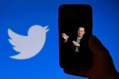 (FILES) In this file photo taken on October 4, 2022, a phone screen displays a photo of Elon Musk with the Twitter logo shown in the background, in Washington, DC. - A landslide of Twitter users responding to an informal poll by new owner Elon Musk voted in favor of a general amnesty for suspended accounts on the platform. The yes/no informal poll comes as Musk faces pushback that his criteria for content moderation is subject to his personal whim, with reinstatements decided for certain accounts and not others. Of 3.16 million respondents to Musks tweeted poll question, 72.4 percent said Twitter should allow suspended accounts back on Twitter as long as they have not broken laws or engaged in egregious spam, Musk posted. (Photo by OLIVIER DOULIERY / AFP)Editoria: ACELocal: WashingtonIndexador: OLIVIER DOULIERYSecao: economy (general)Fonte: AFPFotógrafo: STF<!-- NICAID(15276213) -->