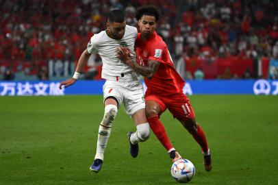 Moroccos midfielder #07 Hakim Ziyech fights for the ball with Canadas forward #11 Tajon Buchanan during the Qatar 2022 World Cup Group F football match between Canada and Morocco at the Al-Thumama Stadium in Doha on December 1, 2022. (Photo by Patrick T. Fallon / AFP)Editoria: SPOLocal: DohaIndexador: PATRICK T. FALLONSecao: soccerFonte: AFPFotógrafo: STF<!-- NICAID(15282269) -->