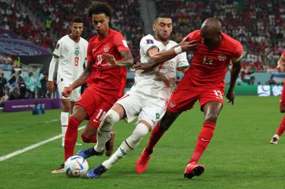 Moroccos midfielder #07 Hakim Ziyech (2nd R) fights for the ball with Canadas forward #11 Tajon Buchanan and midfielder #13 Atiba Hutchinson (R) during the Qatar 2022 World Cup Group F football match between Canada and Morocco at the Al-Thumama Stadium in Doha on December 1, 2022.FADEL SENNA / AFPEditoria: SPOLocal: DohaIndexador: FADEL SENNASecao: soccerFonte: AFPFotógrafo: STF<!-- NICAID(15282270) -->