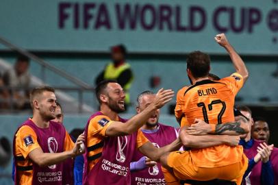 Netherlands defender #17 Daley Blind (C) celebrates with teammates after he scored his teams second goal during the Qatar 2022 World Cup round of 16 football match between the Netherlands and USA at Khalifa International Stadium in Doha on December 3, 2022. (Photo by Anne-Christine POUJOULAT / AFP)<!-- NICAID(15284829) -->