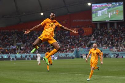 Netherlands defender #22 Denzel Dumfries celebrates scoring his teams third goal during the Qatar 2022 World Cup round of 16 football match between the Netherlands and USA at Khalifa International Stadium in Doha on December 3, 2022. (Photo by ADRIAN DENNIS / AFP)<!-- NICAID(15284835) -->