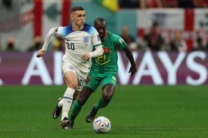 Englands forward #20 Phil Foden (L) fights for the ball with Senegals defender #21 Youssouf Sabaly during the Qatar 2022 World Cup round of 16 football match between England and Senegal at the Al-Bayt Stadium in Al Khor, north of Doha on December 4, 2022. (Photo by Adrian DENNIS / AFP)Editoria: SPOLocal: Al KhorIndexador: ADRIAN DENNISSecao: soccerFonte: AFPFotógrafo: STF<!-- NICAID(15285416) -->