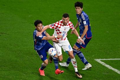 Croatias midfielder #04 Ivan Perisic fights for the ball with Japans players during the Qatar 2022 World Cup round of 16 football match between Japan and Croatia at the Al-Janoub Stadium in Al-Wakrah, south of Doha on December 5, 2022. (Photo by Anne-Christine POUJOULAT / AFP)Editoria: SPOLocal: DohaIndexador: ANNE-CHRISTINE POUJOULATSecao: soccerFonte: AFPFotógrafo: STF<!-- NICAID(15285954) -->