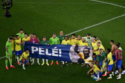 Brazils players hold a banner dedicated to banner Brazilian football legend Pele at the end of the Qatar 2022 World Cup round of 16 football match between Brazil and South Korea at Stadium 974 in Doha on December 5, 2022. (Photo by Antonin THUILLIER / AFP)Editoria: SPOLocal: DohaIndexador: ANTONIN THUILLIERSecao: soccerFonte: AFPFotógrafo: STF<!-- NICAID(15286594) -->