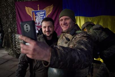 This handout picture taken and released by the Ukrainian Presidential press service on December 6, 2022, shows Ukrainian President Volodymyr Zelensky posing for a selfie picture with a Ukrainian soldier as he visits the Donetsk region, amid the Russian invasion of Ukraine. - President Volodymyr Zelensky on December 6, 2022 visited the frontline region of Donetsk in east Ukraine, describing fighting in the area as difficult with Russian forces pushing to capture the industrial city of Bakhmut. From the bottom of my heart, I congratulate you on this great holiday, the Day of the Armed Forces, said Zelensky, who was later shown meeting soldiers and distributing awards. (Photo by UKRAINIAN PRESIDENTIAL PRESS SERVICE / AFP) / RESTRICTED TO EDITORIAL USE - MANDATORY CREDIT AFP PHOTO / UKRAINIAN PRESIDENTIAL PRESS SERVICE  - NO MARKETING NO ADVERTISING CAMPAIGNS - DISTRIBUTED AS A SERVICE TO CLIENTS<!-- NICAID(15287163) -->