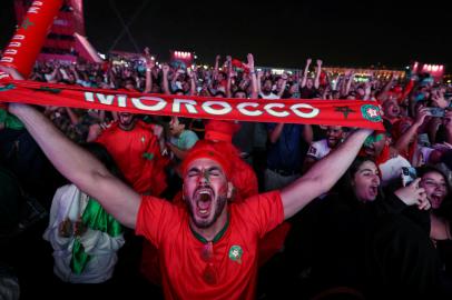 Moroccos supporters celebrate after their team won the Qatar 2022 World Cup round 16 football match between Morocco and Spain, at the FIFA fan zone in Doha, on December 6, 2022. (Photo by MAHMUD HAMS / AFP)<!-- NICAID(15288611) -->