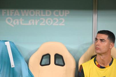 Portugals forward #07 Cristiano Ronaldo sits on the bench during the Qatar 2022 World Cup round of 16 football match between Portugal and Switzerland at Lusail Stadium in Lusail, north of Doha on December 6, 2022. (Photo by PATRICIA DE MELO MOREIRA / AFP)<!-- NICAID(15288263) -->