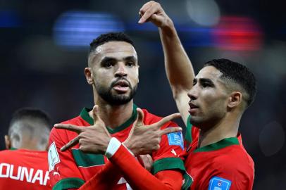 Moroccos forward #19 Youssef En-Nesyri (L) celebrates scoring the opening goal with Moroccos defender #02 Achraf Hakimi during the Qatar 2022 World Cup quarter-final football match between Morocco and Portugal at the Al-Thumama Stadium in Doha on December 10, 2022. (Photo by PATRICIA DE MELO MOREIRA / AFP)<!-- NICAID(15292095) -->