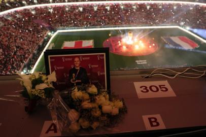 A tribute for US journalist Grant Wahl, who died after he collapsed in the stadiums press area while covering the match between Argentina and Netherlands, can be seen in the media tribune ahead of the Qatar 2022 World Cup quarter-final football match between England and France at the Al-Bayt Stadium in Al Khor, north of Doha, on December 10, 2022. (Photo by JACK GUEZ / AFP)<!-- NICAID(15292164) -->