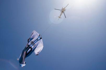 A helicopter carries a giant t-shirt of Argentine forward Lionel Messi over Rosario, Argentina, on December 13, 2022, before the Qatar 2022 World Cup semi-final football match between Argentina and Croatia. (Photo by AFP)<!-- NICAID(15294466) -->