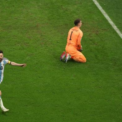 Argentinas forward #10 Lionel Messi celebrates scoring his teams first goal past Croatias goalkeeper #01 Dominik Livakovic during the Qatar 2022 World Cup football semi-final match between Argentina and Croatia at Lusail Stadium in Lusail, north of Doha on December 13, 2022. (Photo by Adrian DENNIS / AFP)Editoria: SPOLocal: DohaIndexador: ADRIAN DENNISSecao: soccerFonte: AFPFotógrafo: STF<!-- NICAID(15294528) -->