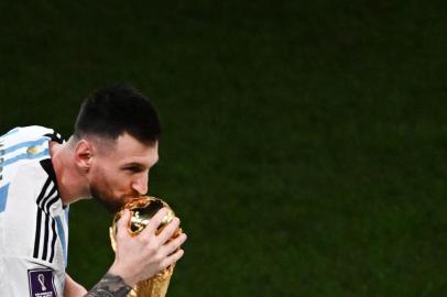 Argentinas forward #10 Lionel Messi kisses the World Cup Trophy at the end of the Qatar 2022 World Cup final football match between Argentina and France at Lusail Stadium in Lusail, north of Doha on December 18, 2022. (Photo by Jewel SAMAD / AFP)Editoria: SPOLocal: DohaIndexador: JEWEL SAMADSecao: soccerFonte: AFPFotógrafo: STF<!-- NICAID(15298585) -->