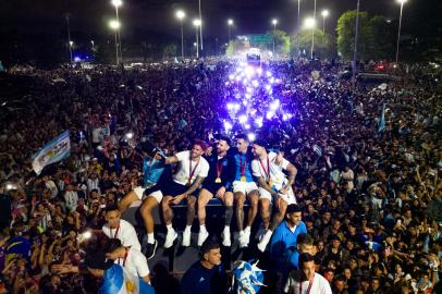 Argentinas captain and forward Lionel Messi (C) holds the FIFA World Cup Trophy on board a bus as he celebrates alongside teammates and supporters after winning the Qatar 2022 World Cup tournament in Ezeiza, Buenos Aires province, Argentina on December 20, 2022. (Photo by Tomas CUESTA / AFP)<!-- NICAID(15300150) -->