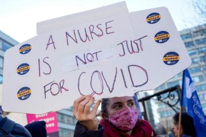 A healthcare workers holds a placard at a picket line outside St Thomas Hospital in London on December 20, 2022. - UK nurses staged a second unprecedented strike amid an increasingly acrimonious fight with the government for better wages and warnings that patient safety could be jeopardised. (Photo by Niklas HALLEN / AFP)Editoria: HTHLocal: LondonIndexador: NIKLAS HALLENSecao: strikeFonte: AFPFotógrafo: STR<!-- NICAID(15300151) -->