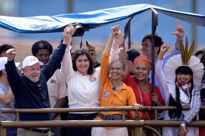 (L-R) Brazilian former President (2003-2010) and presidential candidate for the leftist Workers Party (PT) Luiz Inacio Lula da Silva, former presidential candidate Simone Tebet, former Environment Minister Marina Silva, and federal deputies Dandara Tonantzin and Celia Xakriaba raise their arms during a campaign rally between Belo Horizonte and Ribeirao das Neves, Minas Gerais state, Brazil, on October 22, 2022. - Veteran leftist Luiz Inacio Lula da Silva said he is keeping an eye on poll numbers showing his lead narrowing over far-right incumbent Jair Bolsonaro for Brazils October 30 presidential runoff but is confident he will win. (Photo by DOUGLAS MAGNO / AFP)<!-- NICAID(15250262) -->