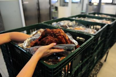 CAXIAS DO SUL, RS, BRASIL, 23/12/2022. Mais de 50 pessoas montam 630 ceias de Natal para doar a famílias e pessoas em vulnerabilidade social em Caxias. As aves, peru ou chesters, começaram a ser preparadas por volta das 5h30min,  no Centro de Acolhida e Formação Mão Amiga, no Restaurante Popular. Há nove fornos e três galheteiras e cada ave leva em torno de duas a três horas para assar.  As aves forma doadas por uma empresa. Os ingredientes da ceia  foram arrecadados pelos voluntários ou comprados com os valores doados ao projeto para montar os kits. (Bruno Todeschini/Agência RBS)<!-- NICAID(15303462) -->