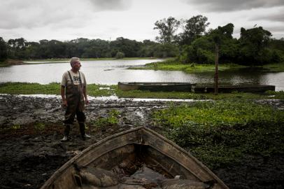 Gravataí, RS, Brasil, 28-12-2022: O servidor público aposentado Breno Duarte observa o rio Gravataí com nível abaixo do normal no Balneário Passo das Canoas. Seca do Rio Gravataí afeta Região Metropolitana de Porto Alegre. Foto: Mateus Bruxel / Agência RBSIndexador: Mateus Bruxel<!-- NICAID(15306737) -->