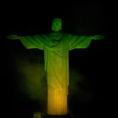 The Christ The Redeemer statue, on top of Corcovado mountain, is illuminated in green and yellow, the colours of the Brazilian national flag, in honour of Brazilian football legend Pele, in Rio de Janeiro, Brazil on December 29, 2022, just hours after his passing at a Sao Paulo hospital. - Brazilian football icon Pele, widely regarded as the greatest player of all time and a three-time World Cup winner who masterminded the beautiful game, died on Thursday at the age of 82. The Albert Einstein hospital treating Pele said in a statement his death after a long battle with cancer was caused by multiple organ failure. (Photo by Mauro PIMENTEL / AFP)Editoria: SPOLocal: Rio de JaneiroIndexador: MAURO PIMENTELSecao: soccerFonte: AFPFotógrafo: STF<!-- NICAID(15308046) -->