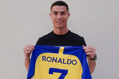 A handout picture released by Saudi Arabias al-Nasr football club shows Portugals forward Cristiano Ronaldo posing with the clubs number seven jersey in Madrid on December 30, 2022 upon signing for the Saudi Arabian club. - Cristiano Ronaldo on December 30 signed for al-Nasr of Saudi Arabia, the club announced, in a deal believed to be worth more than 200 million euros. The 37-year-old penned a contract which will take him to June 2025. (Photo by Al Nassr Football Club / AFP) / == RESTRICTED TO EDITORIAL USE - MANDATORY CREDIT AFP PHOTO / HO /AL NASSR FOOTBALL CLUB - NO MARKETING NO ADVERTISING CAMPAIGNS - DISTRIBUTED AS A SERVICE TO CLIENTS ==Editoria: SPOLocal: MadridIndexador: -Secao: soccerFonte: Al Nassr Football ClubFotógrafo: STR<!-- NICAID(15309889) -->