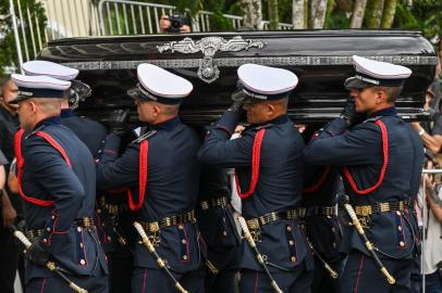 The coffin of the late Brazilian football star Pele arrives to the Santos Memorial Cemetery after the funeral procession in Santos, Sao Paulo state, Brazil on January 3, 2023. - Brazilian football legend Peles remains arrived Tuesday at the cemetery where he will be interred in a mausoleum, after three days of national mourning, a 24-hour wake and a massive funeral procession. Peles casket, draped in the Brazilian flag and that of his longtime club, Santos FC, arrived atop a red firetruck at the Santos Memorial Cemetery, near the stadium where The King began his rise to become what many consider the greatest footballer of all time. (Photo by NELSON ALMEIDA / AFP)Editoria: SOILocal: SantosIndexador: NELSON ALMEIDASecao: soccerFonte: AFPFotógrafo: STF<!-- NICAID(15311228) -->