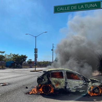 A burning car is seen on the street during an operation to arrest the son of Joaquin El Chapo Guzman, Ovidio Guzman, in Culiacan, Sinaloa state, Mexico, on January 5, 2023. - Mexican security forces on Thursday captured a son of jailed drug kingpin Joaquin El Chapo Guzman, scoring a high-profile win in the fight against powerful cartels days before US President Joe Biden visits. Ovidio Guzman, who was arrested in the northwestern city of Culiacan, is accused of leading a faction of his fathers notorious Sinaloa cartel, Defense Minister Luis Cresencio Sandoval told reporters. (Photo by Juan Carlos CRUZ / AFP)<!-- NICAID(15314551) -->