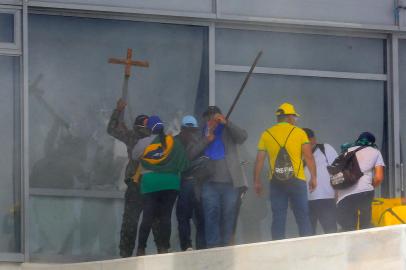 Supporters of Brazilian former President Jair Bolsonaro break a window as they invade Planalto Presidential Palace in Brasilia on January 8, 2023. - Hundreds of supporters of Brazils far-right ex-president Jair Bolsonaro broke through police barricades and stormed into Congress, the presidential palace and the Supreme Court Sunday, in a dramatic protest against President Luiz Inacio Lula da Silvas inauguration last week. (Photo by Sergio Lima / AFP)Editoria: WARLocal: BrasíliaIndexador: SERGIO LIMASecao: demonstrationFonte: AFPFotógrafo: STR<!-- NICAID(15315343) -->