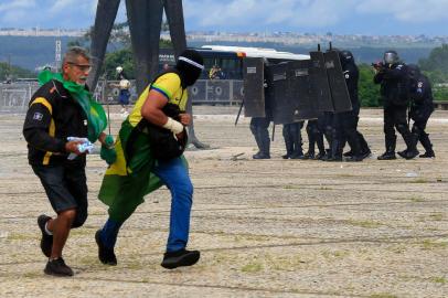 Security forces confront supporters of Brazilian former President Jair Bolsonaro as they invade Planalto Presidential Palace in Brasilia on January 8, 2023. - Hundreds of supporters of Brazils far-right ex-president Jair Bolsonaro broke through police barricades and stormed into Congress, the presidential palace and the Supreme Court Sunday, in a dramatic protest against President Luiz Inacio Lula da Silvas inauguration last week. (Photo by Sergio Lima / AFP)Editoria: WARLocal: BrasíliaIndexador: SERGIO LIMASecao: demonstrationFonte: AFPFotógrafo: STR<!-- NICAID(15315342) -->