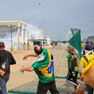 Supporters of Brazilian former President Jair Bolsonaro clash with riot police at Planalto Presidential Palace in Brasilia on January 8, 2023. - Hundreds of supporters of Brazils far-right ex-president Jair Bolsonaro broke through police barricades and stormed into Congress, the presidential palace and the Supreme Court Sunday, in a dramatic protest against President Luiz Inacio Lula da Silvas inauguration last week. (Photo by Sergio Lima / AFP)Editoria: WARLocal: BrasíliaIndexador: SERGIO LIMASecao: demonstrationFonte: AFPFotógrafo: STR<!-- NICAID(15315545) -->