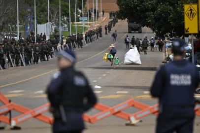 Soldiers dismantle a camp by supporters of Brazils far-right ex-president Jair Bolsonaro that had been set up in front of the Army headquarters in Brasilia, on January 9, 2023, as police forces stand guard a day after backers of the ex-president invaded the Congress, presidential palace and Supreme Court. - Brazilian security forces locked down the area around Congress, the presidential palace and the Supreme Court Monday, a day after supporters of ex-president Jair Bolsonaro stormed the seat of power in riots that triggered an international outcry. Hardline Bolsonaro supporters have been protesting outside army bases calling for a military intervention to stop Lula from taking power since his election win. (Photo by Mauro PIMENTEL / AFP)<!-- NICAID(15315755) -->