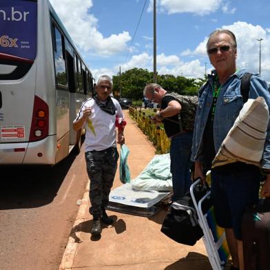 A small group of supporters of Brazils far-right ex-president Jair Bolsonaro who had been arrested after they invaded federal buildings, walk on arrival at the interstate bus terminal after being released by Brazils Federal Police in Brasilia, on January 10, 2023. - Brazilian security forces cleared protest camps on the eve and arrested 1,500 people as President Luiz Inacio Lula da Silva condemned acts of terrorism after a far-right mob stormed the seat of power, unleashing chaos on the capital. Hardline Bolsonaro supporters have been protesting outside army bases calling for a military intervention to stop Lula from taking power since his election win. (Photo by MAURO PIMENTEL / AFP)Editoria: WARLocal: BrasíliaIndexador: MAURO PIMENTELSecao: demonstrationFonte: AFPFotógrafo: STF<!-- NICAID(15317667) -->