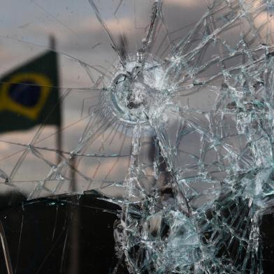 A Brazilian flag is reflected on a broken window of the Supreme Court building in Brasilia on January 10, 2023, two days after thousands of supporters of Brazils far-right ex-president Jair Bolsonaro raided federal buildings. - President Luiz Inacio Lula da Silva condemned acts of terrorism after a far-right mob stormed the seat of power, unleashing chaos on the capital. (Photo by CARL DE SOUZA / AFP)Editoria: WARLocal: BrasíliaIndexador: CARL DE SOUZASecao: crisisFonte: AFPFotógrafo: STF<!-- NICAID(15317834) -->