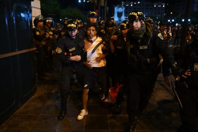 Policemen arrest a protester during a demonstration against the government of Peruvian President Dina Boluarte in Lima on January 12, 2023. - Leftist groups announced mobilizations in Lima this Thursday to demand the resignation of President Dina Boluarte and early elections, as part of the protests that left at least 42 dead in just over a month, with major outbreaks in Andean areas such as Cusco, a mecca of tourism whose airport closed for security. (Photo by ERNESTO BENAVIDES / AFP)<!-- NICAID(15321772) -->