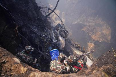 Rescuers inspect the site of a plane crash in Pokhara on January 15, 2023. - An aircraft with 72 people on board crashed in Nepal on January 15, Yeti Airlines and a local official said. (Photo by Yunish Gurung / AFP)<!-- NICAID(15321775) -->