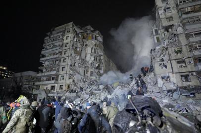 Rescuers works on a residential building destroyed after a missile strike, in Dnipro on January 14, 2023. - A strike on a residential building in the eastern Ukrainian city of Dnipro on January 14, 2023 killed at least five people and wounded 39, officials said, as the president blasted Russian terror. (Photo by vitalii matokha / AFP)<!-- NICAID(15322243) -->