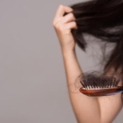 Healthy concept. Woman show her brush with long loss hair and looking at her hair.Indexador: Siam PukkatoFonte: 254112994<!-- NICAID(14840099) -->