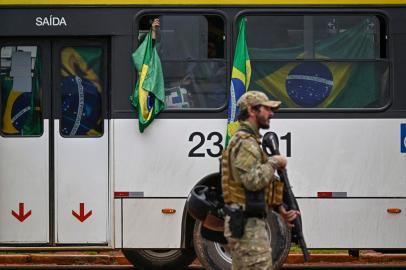 Supporters of Brazils far-right ex-president Jair Bolsonaro in custody, are taken in buses by police forces to the Federal police headquarters to have their identities and criminal records checked for their possible implication in vandalism acts during the invasions to the Congress, presidential palace and Supreme Court, in Brasilia, on January 9, 2023, a day after the pro-Bolsonaro mob ran riots. - Brazilian security forces locked down the area around Congress, the presidential palace and the Supreme Court Monday, a day after supporters of ex-president Jair Bolsonaro stormed the seat of power in riots that triggered an international outcry. Hardline Bolsonaro supporters have been protesting outside army bases calling for a military intervention to stop Lula from taking power since his election win. (Photo by MAURO PIMENTEL / AFP)Editoria: WARLocal: BrasíliaIndexador: MAURO PIMENTELSecao: demonstrationFonte: AFPFotógrafo: STF<!-- NICAID(15316086) -->