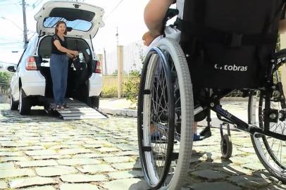 CAXIAS DO SUL, RS, BRASIL, 19/01/2023. Carro adaptado A falta de acessibilidade costuma ser um desafio diário para muitas pessoas com deficiência em Caxias do Sul. E foi pensando justamente em atender a este público que empreendedores do município começaram a investir em carros adaptados e no acompanhamento durante os deslocamentos. Essa novidade traz alívio a quem depende do serviço, caso do estudante Douglas Kusse, que perdeu o movimento das pernas e dos braços há sete anos após ter sofrido um acidente em uma piscina. (Juliano Gambini/RBS TV)<!-- NICAID(15326754) -->