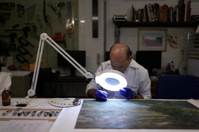 An employee of the Federal Senate works on recovering works of art damaged during the protests in the federal capital on January 8, in Brasilia, on January 19, 2023. (Photo by DOUGLAS MAGNO / AFP)<!-- NICAID(15327483) -->