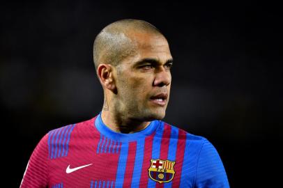 (FILES) In this file photo taken on February 27, 2022 Barcelonas Brazilian defender Dani Alves looks on during the Spanish league football match between FC Barcelona and Athletic Club Bilbao at the Camp Nou stadium in Barcelona. - Former Brazil defender Dani Alves was taken into custody on January 20, 2023 in Spain over allegations that he sexually assualted a woman at a Barcelona nightclub in December, police said. The 39-year-old player was summoned to a Barcelona police station where he was taken into custody and will now be questioned by a judge, said a spokesman for Catalonias regional police force, the Mossos dEsquadra. (Photo by Pau BARRENA / AFP)Editoria: SPOLocal: BarcelonaIndexador: PAU BARRENASecao: soccerFonte: AFPFotógrafo: STR<!-- NICAID(15329443) -->