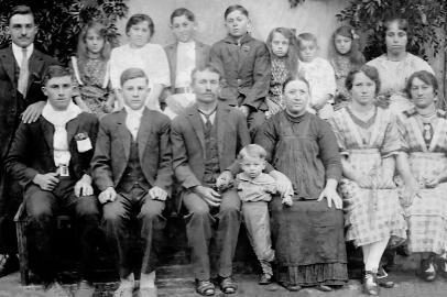 A família de Cipriano Pezzini e Joanna Baruffi, nos anos 1920: em pé, os irmãos Máximo Conrado, Clementina Juditha, Maria, Bernardino, Luciano Antonio, Amabile, Natal Bibiano, Theodora e Catharina. À frente, João Chrisostomo, Dionizio, seu Cipriano, o menino Sabino Giuseppe, dona Joanna, Rosa e Ermínia.<!-- NICAID(15330544) -->