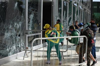 Supporters of Brazilian former President Jair Bolsonaro destroy a window of the the plenary of the Supreme Court in Brasilia on January 8, 2023. - Hundreds of supporters of Brazils far-right ex-president Jair Bolsonaro broke through police barricades and stormed into Congress, the presidential palace and the Supreme Court Sunday, in a dramatic protest against President Luiz Inacio Lula da Silvas inauguration last week. (Photo by Ton MOLINA / AFP)Editoria: WARLocal: BrasíliaIndexador: TON MOLINASecao: demonstrationFonte: AFPFotógrafo: STR<!-- NICAID(15315597) -->