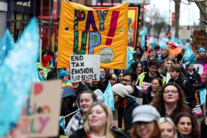 Teachers and members of the National Education Union (NEU) hold placards during a demonstration called by the NEU trade unions in the streets of Reading, on February 1, 2023 during a national strike day. - Children missed school and commuters faced severe disruption in the UK as half a million workers staged walkouts calling for higher wages in the largest such strikes in over a decade. (Photo by Adrian DENNIS / AFP)<!-- NICAID(15336666) -->