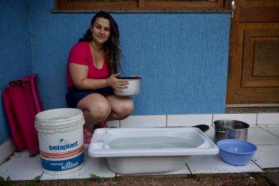 Gravataí, RS, Brasil, 01/02/2023 - Falta d¿água em Gravataí. Na foto Winnie Santos, 31 anos, dona de casa. Usou todos os vasilhames disponíveis para encher d¿água. - Foto: Jefferson Botega/Agência RBSIndexador: Jeff Botega<!-- NICAID(15336957) -->